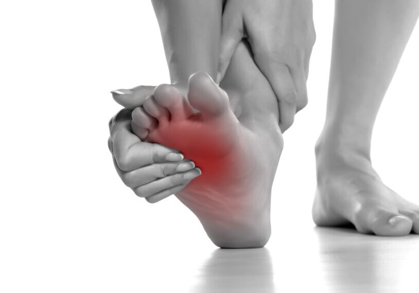 woman massaging her painful foot on white background